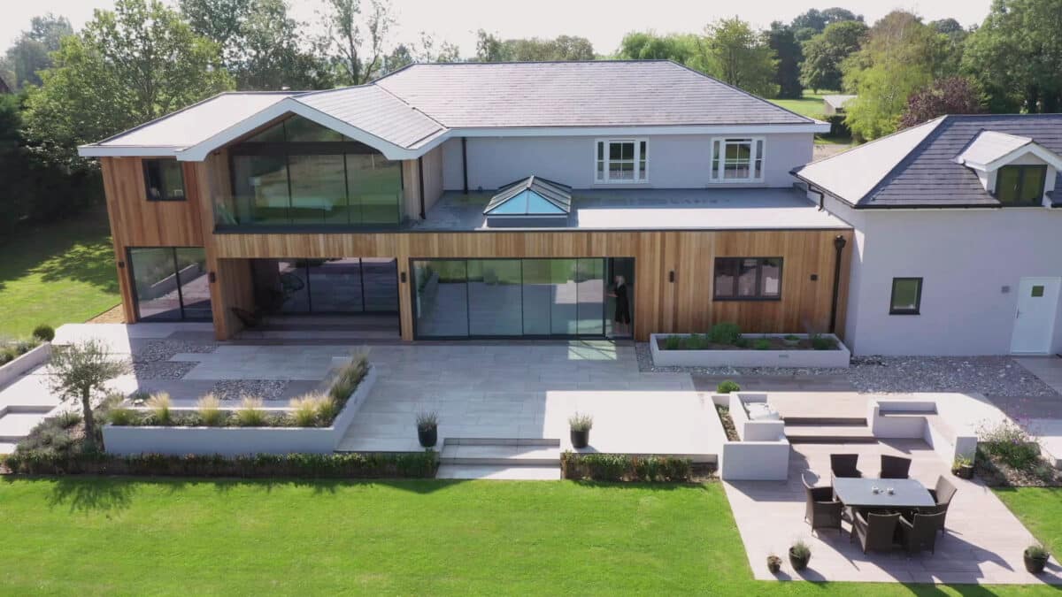 Modern house featuring extensive aluminium sliding doors and bifold glazing that flood the contemporary home with natural light and countryside views.