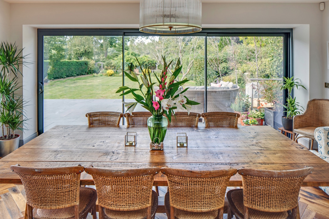 theEDGE2 ultra-slimline glass sliding door opening onto landscaped garden, featuring narrow frames and seamless indoor-outdoor connection in contemporary dining space.